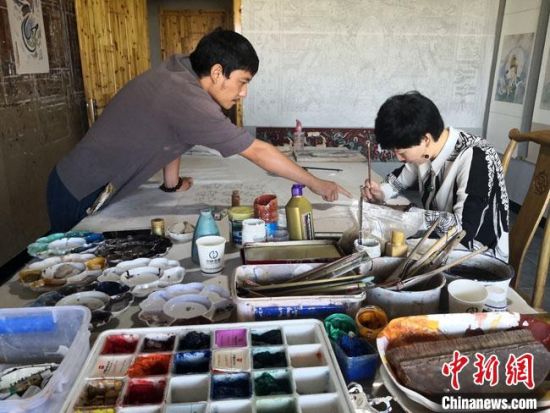 圖為2020年8月下旬,敦煌“80后”畫家張杰龍(左)在為云南麗江“學(xué)生”莫北講解敦煌壁畫的繪畫技巧。 馮志軍 攝 圖為2020年8月下旬,敦煌“80后”畫家張杰龍(左)在為云南麗江“學(xué)生”莫北講解敦煌壁畫的繪畫技巧。 馮志軍 攝
