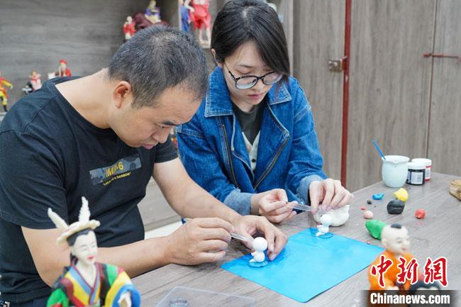 <a target='_blank'  data-cke-saved- >中新社</a>記者(右)現場體驗面塑制作過程。　陳爭強 攝