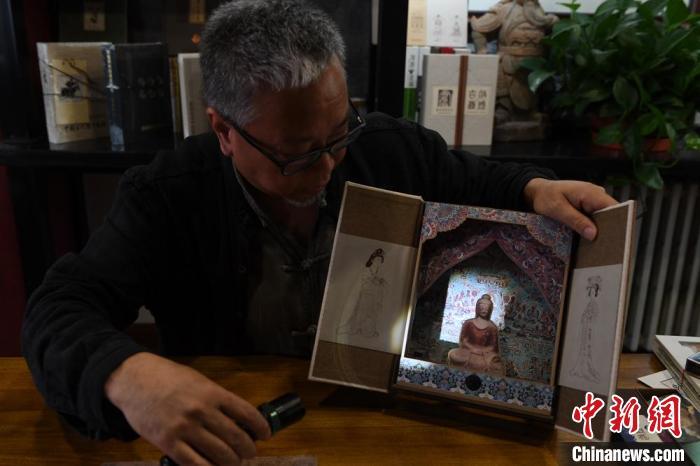 圖為讀者出版集團讀者晉林工作室獨立出品人徐晉林，展示互動性強的敦煌題材手工書。(資料圖) 楊艷敏 攝