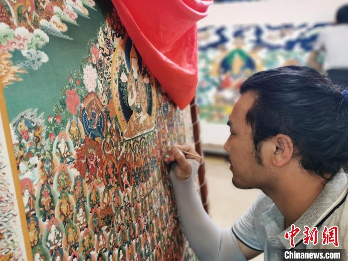 圖為更登才讓的徒弟繪畫唐卡?！執砀?攝