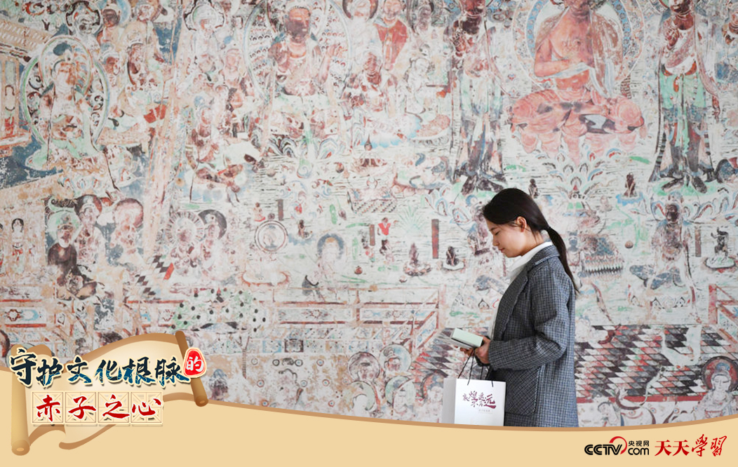 2023年4月25日，敦煌研究院文物數(shù)字化保護(hù)團(tuán)隊(duì)創(chuàng)意營銷人員廖雪婷從一幅高保真復(fù)制壁畫前走過。